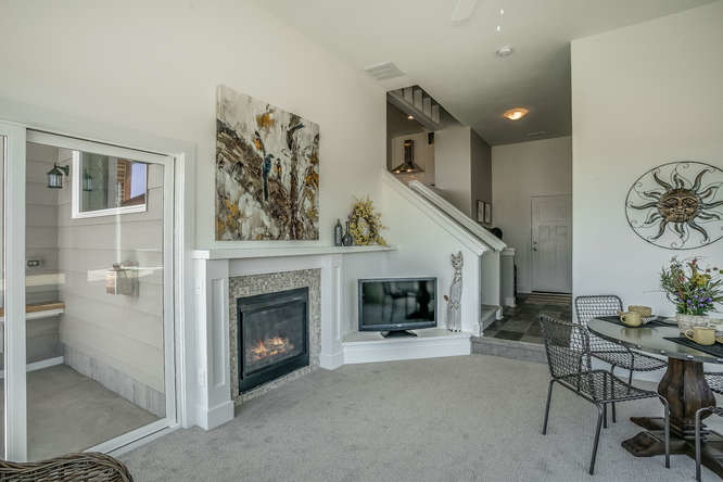 Großes, Repräsentatives, Abgetrenntes Modernes Wohnzimmer mit grauer Wandfarbe, Teppichboden, Kamin, gefliester Kaminumrandung, freistehendem TV und grauem Boden in Wichita