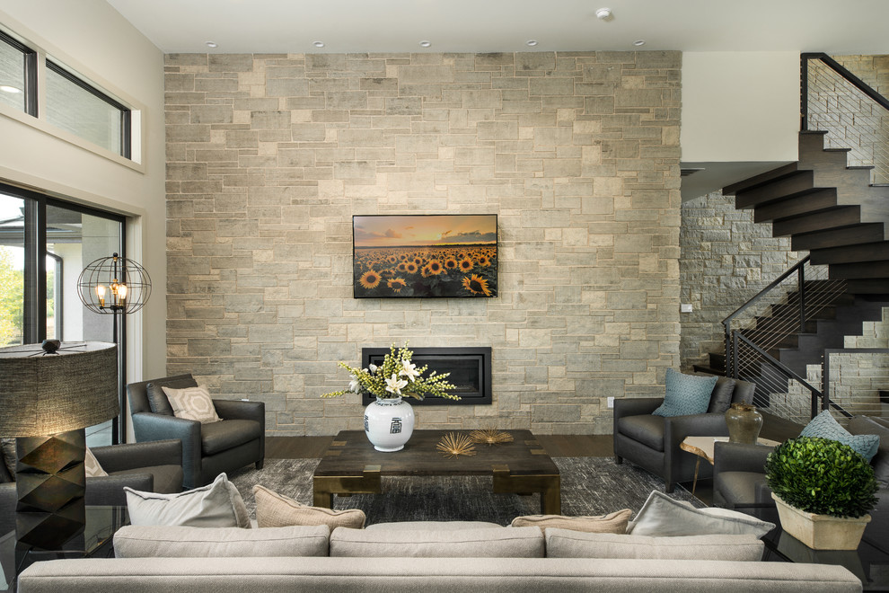 На фото: большая открытая гостиная комната в современном стиле с телевизором на стене, горизонтальным камином, белыми стенами, паркетным полом среднего тона и фасадом камина из камня