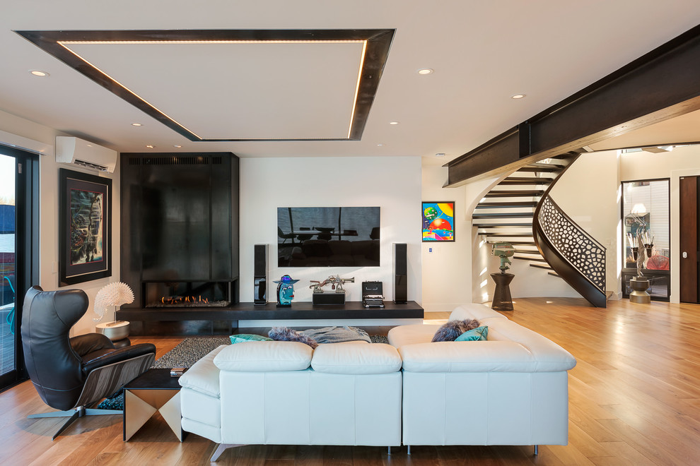 Modelo de salón abierto contemporáneo con paredes blancas, suelo de madera en tonos medios, chimenea lineal, televisor colgado en la pared y suelo marrón