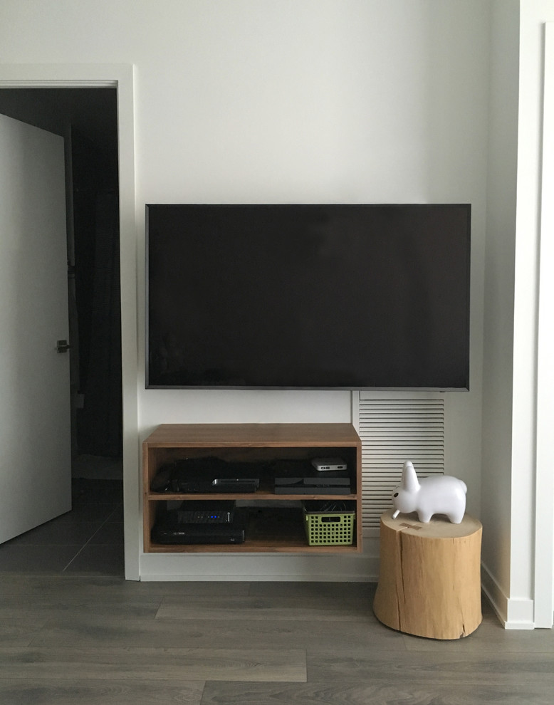 Aménagement d'un petit salon moderne ouvert avec un mur blanc, parquet foncé et un téléviseur fixé au mur.