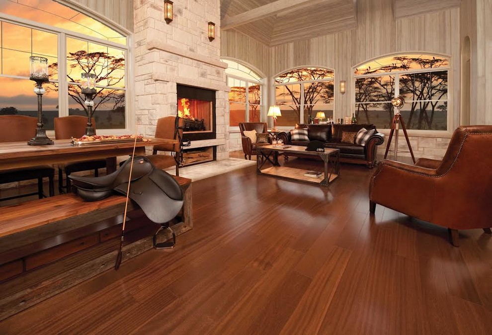 Modelo de salón para visitas tipo loft de estilo americano grande con paredes beige, suelo de madera en tonos medios, todas las chimeneas, marco de chimenea de piedra y suelo marrón