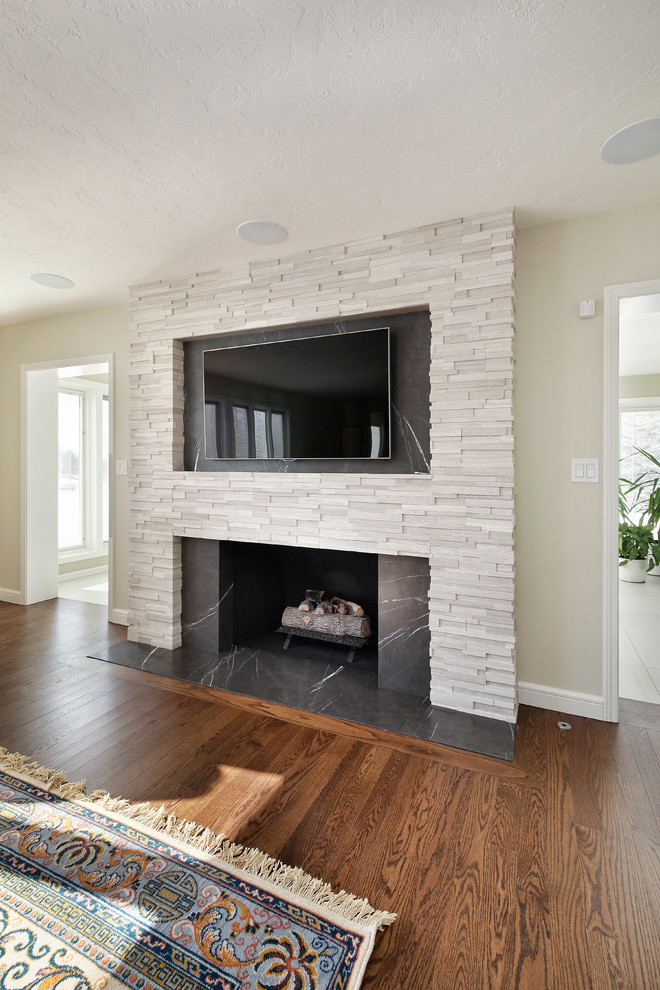 Example of a trendy living room design in Chicago with a standard fireplace, a stone fireplace and a wall-mounted tv