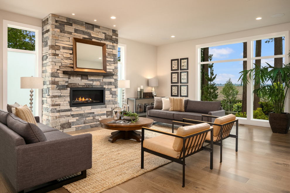 Cette photo montre un grand salon tendance ouvert avec un sol en bois brun, une cheminée ribbon et un manteau de cheminée en pierre de parement.