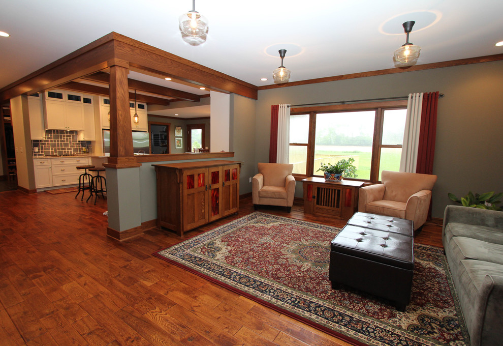 Foto de salón abierto de estilo americano con paredes verdes, suelo de madera en tonos medios y televisor retractable