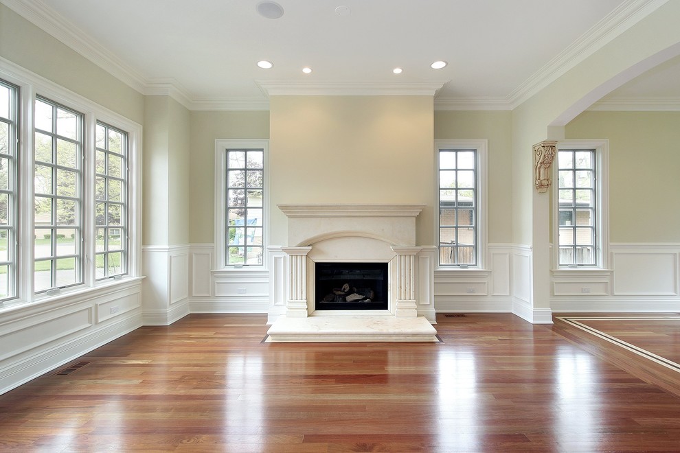 This is an example of a large nautical formal enclosed living room in Los Angeles with beige walls, medium hardwood flooring, a standard fireplace, a plastered fireplace surround and no tv.