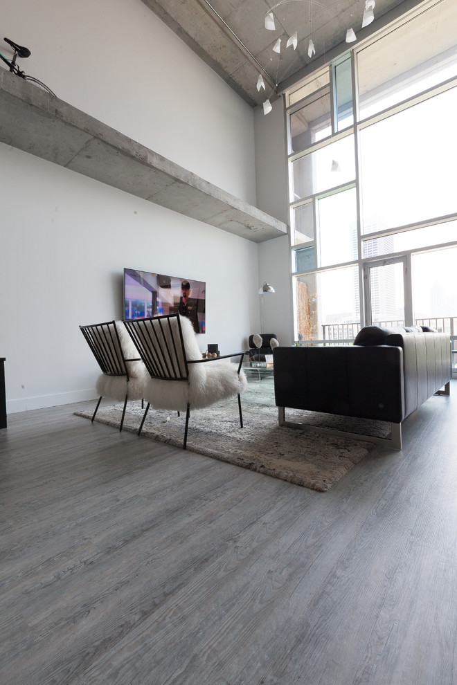 Idee per un soggiorno minimalista di medie dimensioni e stile loft con pareti bianche, pavimento in vinile e TV a parete