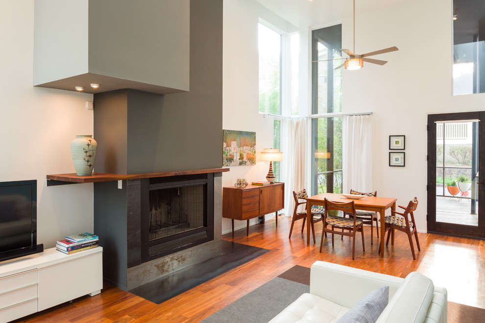 Offenes Modernes Wohnzimmer mit weißer Wandfarbe, dunklem Holzboden, Kamin und freistehendem TV in Atlanta