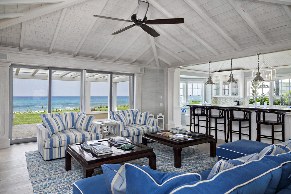 Свежая идея для дизайна: большая открытая гостиная комната в морском стиле с белыми стенами, синим диваном и ковром на полу без телевизора - отличное фото интерьера