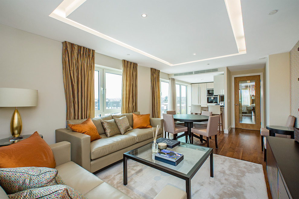Classic open plan living room in London with beige walls and medium hardwood flooring.