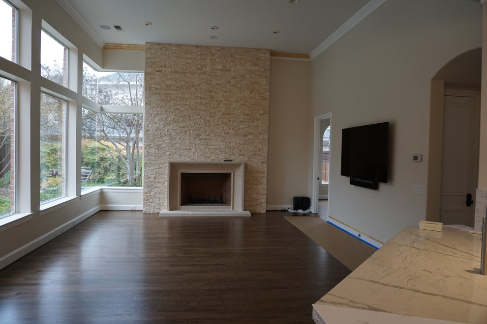 Mid-sized elegant open concept dark wood floor living room photo in Dallas with beige walls, a standard fireplace, a stone fireplace and a wall-mounted tv
