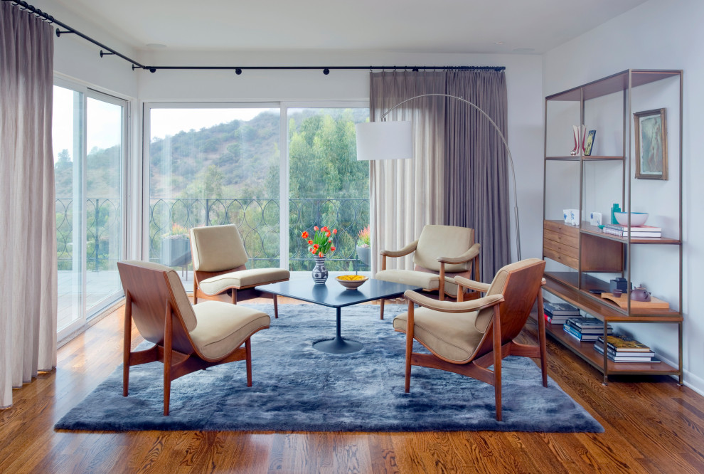 Foto di un soggiorno minimalista con pareti bianche, pavimento in legno massello medio e pavimento marrone