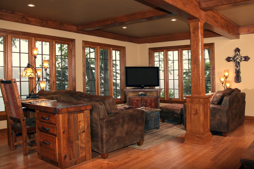 Design ideas for a medium sized rustic formal open plan living room in Milwaukee with beige walls, medium hardwood flooring, no fireplace, a freestanding tv and a stone fireplace surround.