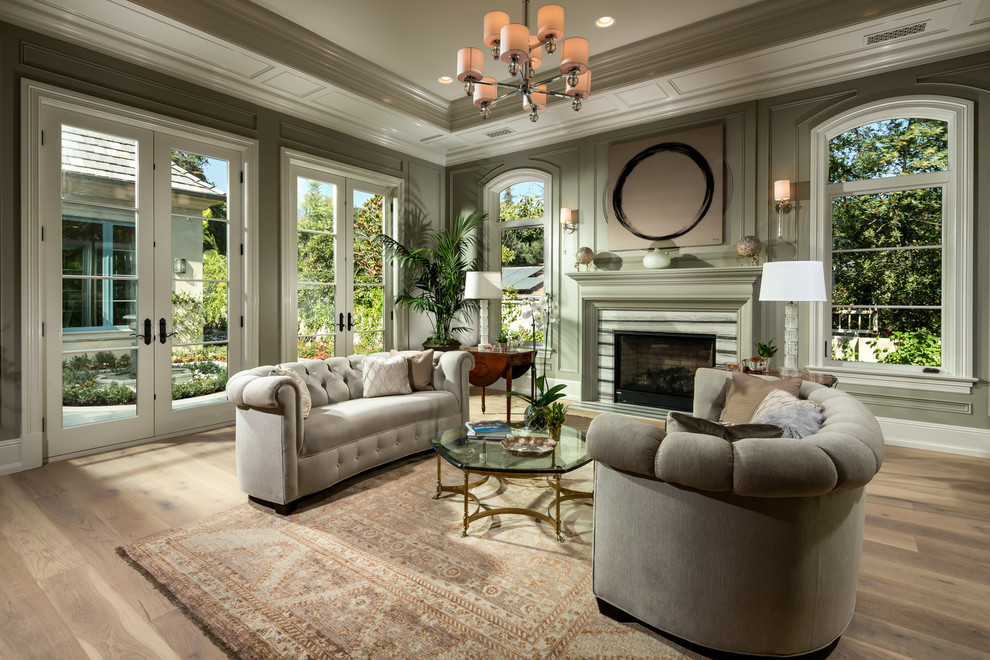 Repräsentatives, Fernseherloses Klassisches Wohnzimmer mit grüner Wandfarbe, braunem Holzboden und Kamin in Los Angeles