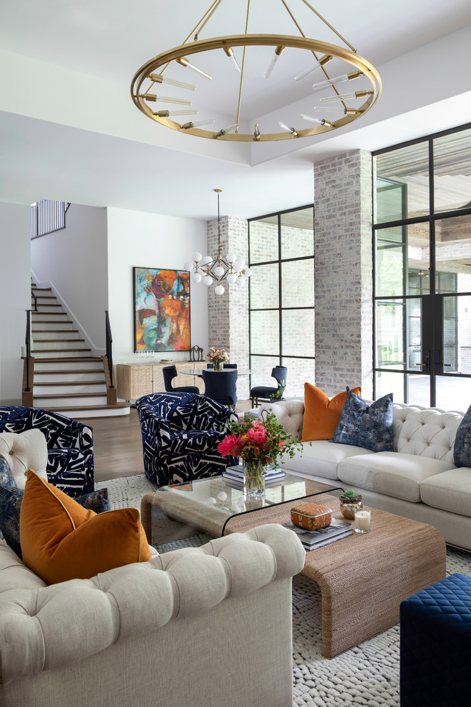 Example of a huge transitional open concept medium tone wood floor and brown floor living room design in Houston with a bar, white walls, a standard fireplace and a stone fireplace