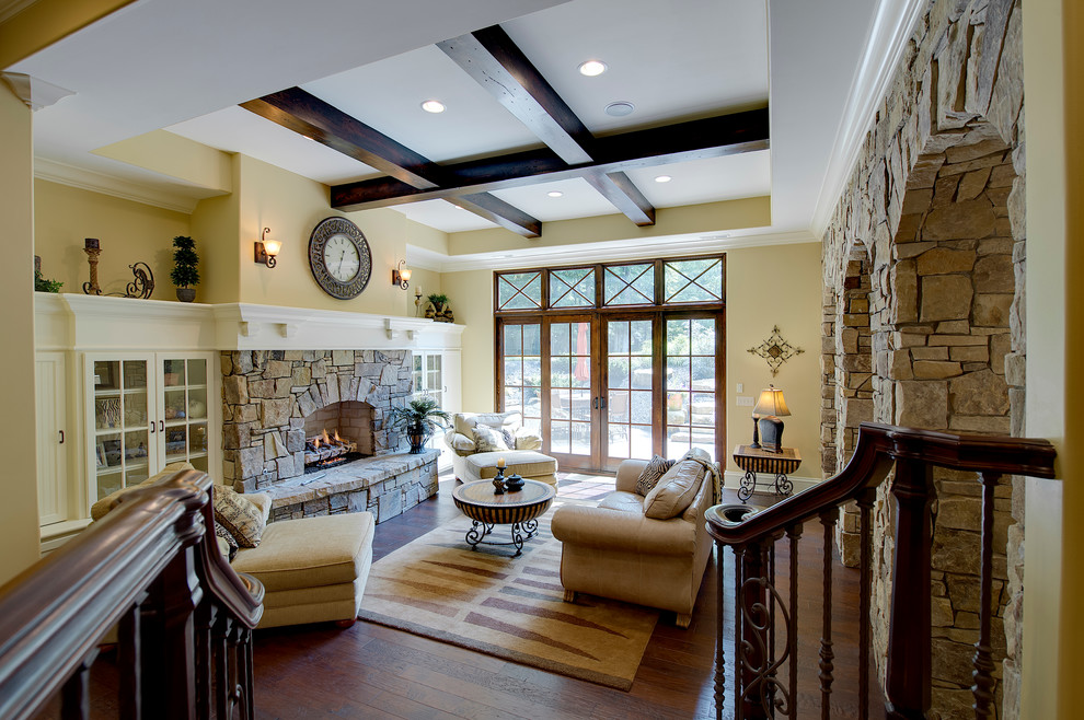 Photo of a medium sized traditional enclosed living room in Indianapolis with yellow walls, dark hardwood flooring, a standard fireplace, a stone fireplace surround and no tv.