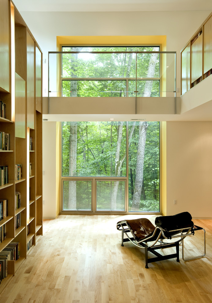 Exemple d'un salon tendance avec une bibliothèque ou un coin lecture et un mur blanc.
