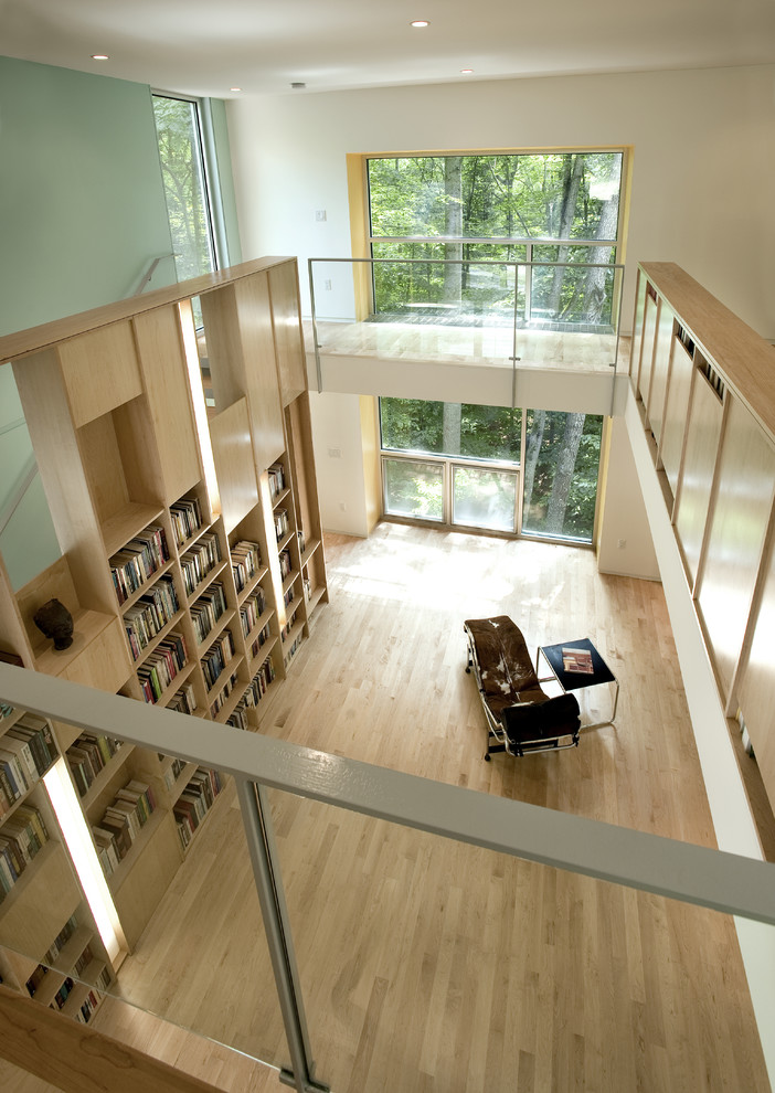 Inspiration pour un salon design avec un mur vert et une bibliothèque ou un coin lecture.
