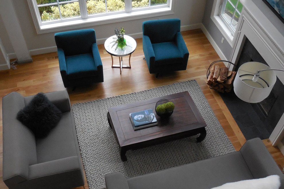 Mittelgroßes, Fernseherloses, Offenes Modernes Wohnzimmer mit grauer Wandfarbe, hellem Holzboden, Kamin und Kaminumrandung aus Stein in Portland