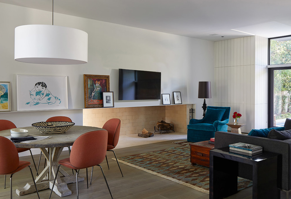 Imagen de salón contemporáneo con paredes blancas, suelo de madera en tonos medios, televisor colgado en la pared y suelo marrón