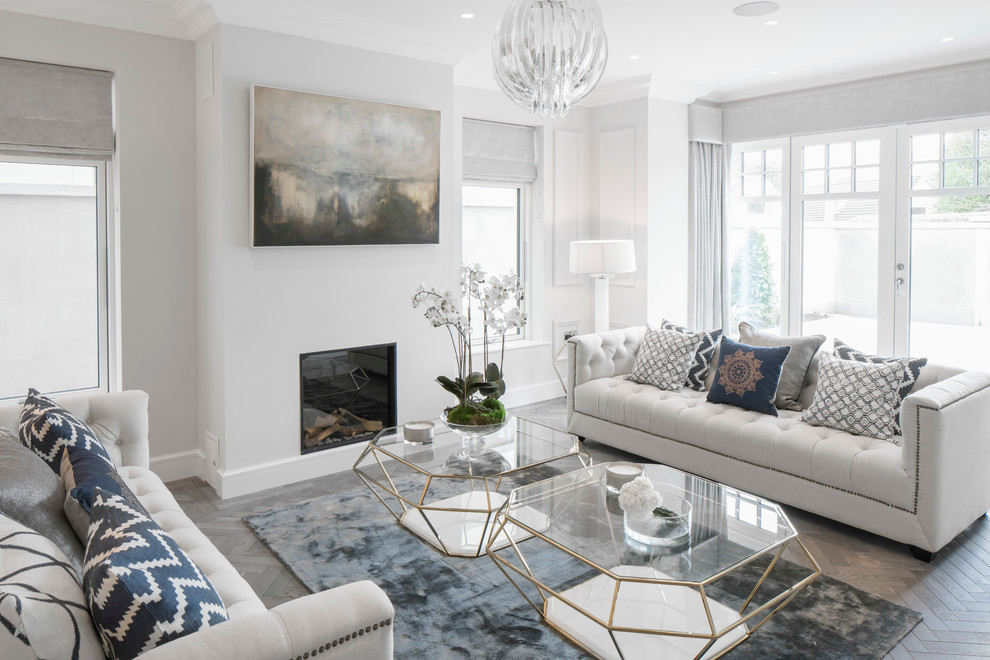 Inspiration for a medium sized traditional formal enclosed living room in Dublin with white walls, light hardwood flooring, a standard fireplace, a plastered fireplace surround and feature lighting.