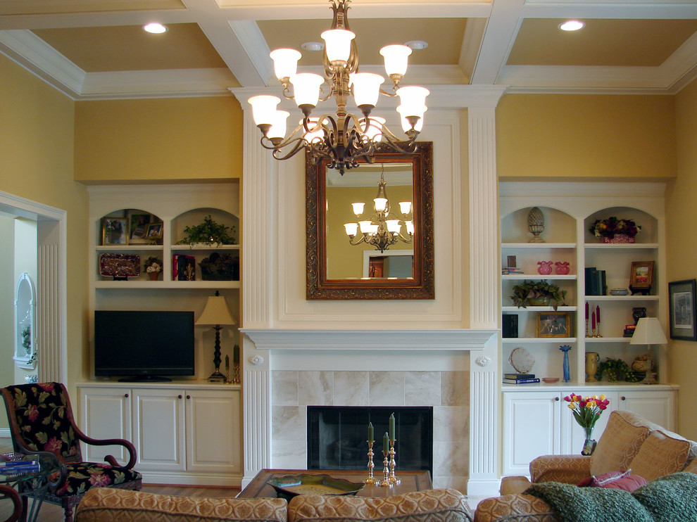 Photo of a large classic living room in Cincinnati with a built-in media unit, yellow walls, medium hardwood flooring, a standard fireplace and a tiled fireplace surround.