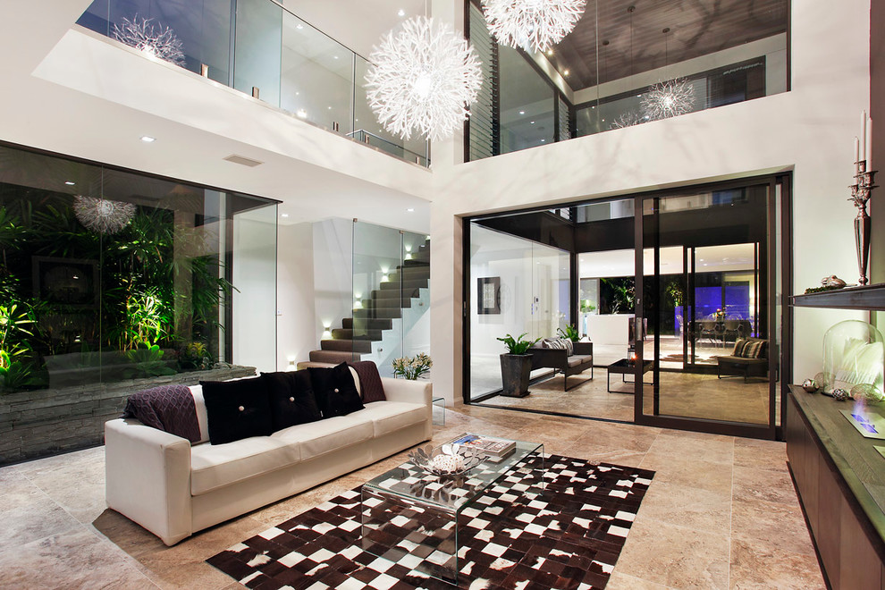 Large contemporary formal open plan living room in Sydney with white walls, travertine flooring and a concealed tv.