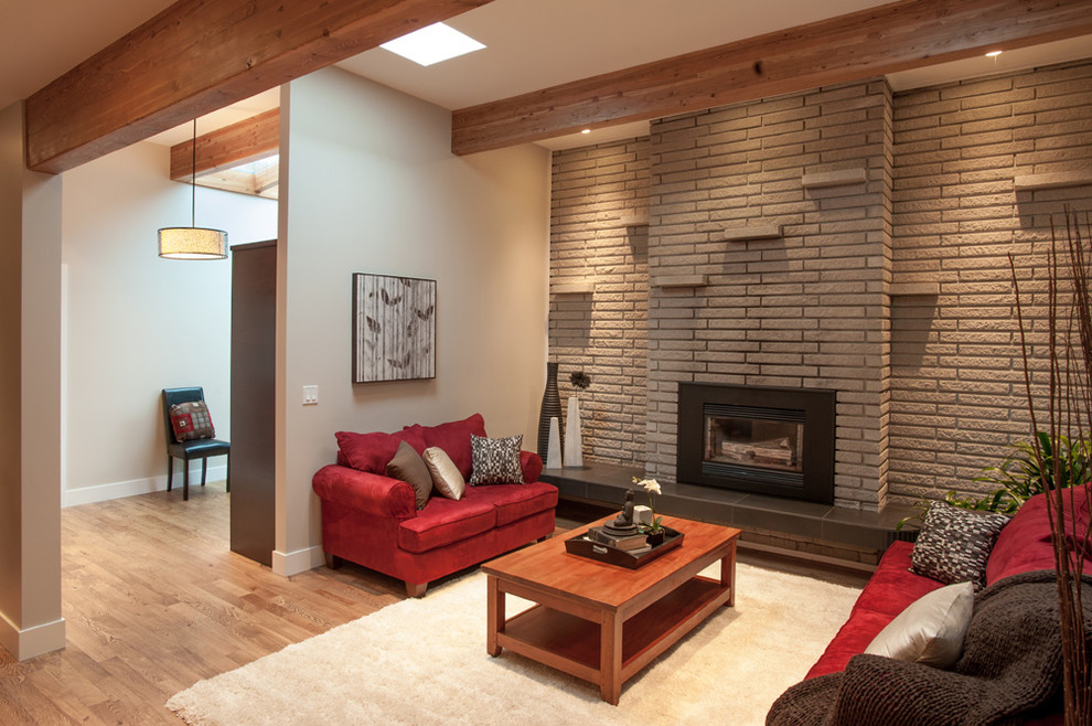 Mid-sized trendy formal medium tone wood floor living room photo in Vancouver with beige walls, a brick fireplace and no tv