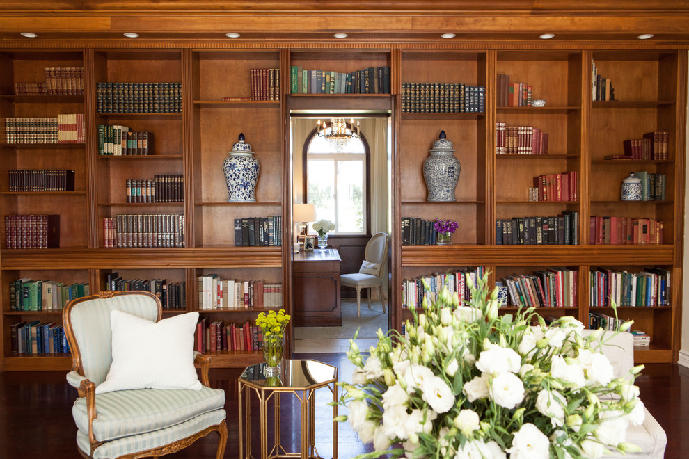 На фото: гостиная комната в классическом стиле с с книжными шкафами и полками