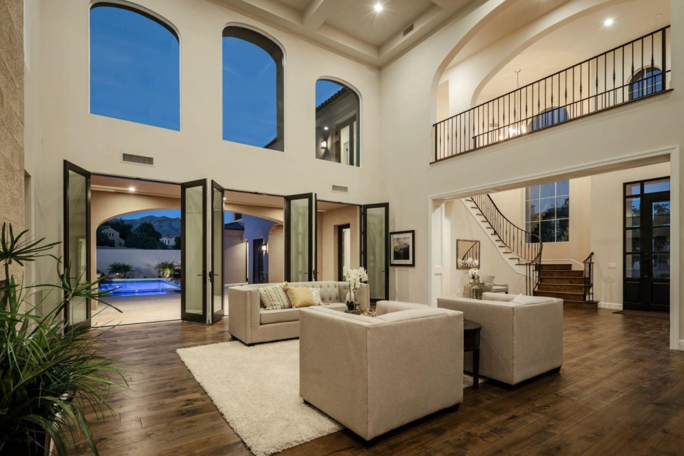 Inspiration for a large mediterranean medium tone wood floor, brown floor and coffered ceiling living room remodel in Phoenix with a standard fireplace and a stone fireplace