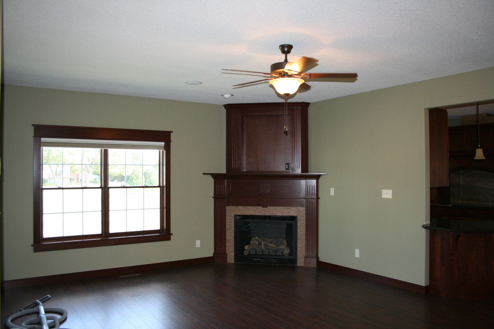 Example of a large arts and crafts formal and open concept ceramic tile living room design in Cedar Rapids with a corner fireplace, a wood fireplace surround and green walls