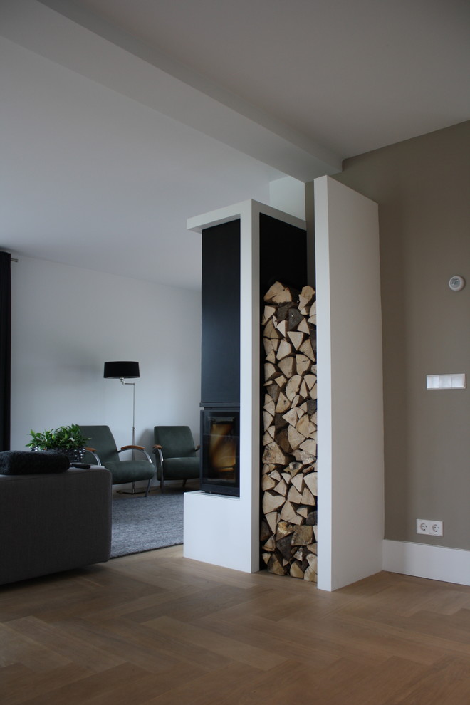 Idée de décoration pour un salon minimaliste avec un mur blanc et une cheminée d'angle.