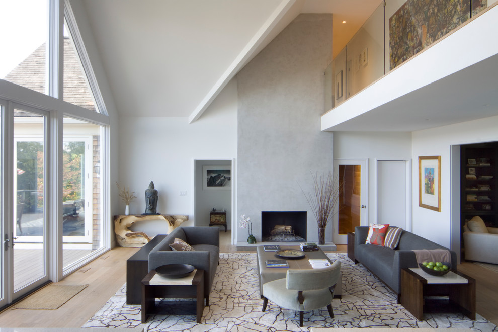 Стильный дизайн: гостиная комната в современном стиле с белыми стенами, паркетным полом среднего тона и стандартным камином - последний тренд