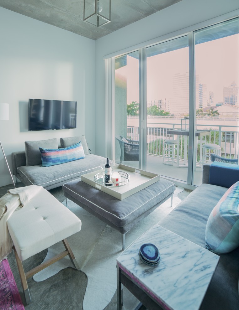 Inspiration for a small traditional mezzanine living room in Miami with white walls, concrete flooring and a wall mounted tv.