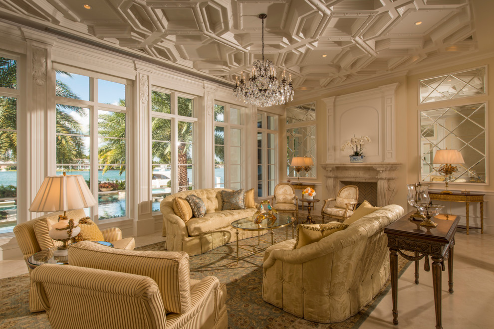Repräsentatives, Fernseherloses, Großes, Offenes Klassisches Wohnzimmer mit beiger Wandfarbe, Kamin, Porzellan-Bodenfliesen und Kaminumrandung aus Stein in Miami