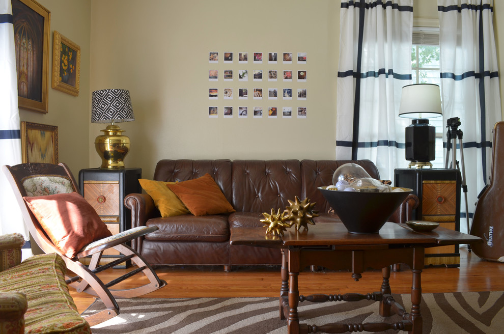 Идея дизайна: гостиная комната в стиле фьюжн с бежевыми стенами и коричневым диваном