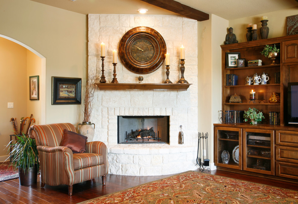 Foto de salón para visitas abierto clásico de tamaño medio con paredes beige, suelo de madera en tonos medios, pared multimedia, chimenea de esquina y marco de chimenea de piedra
