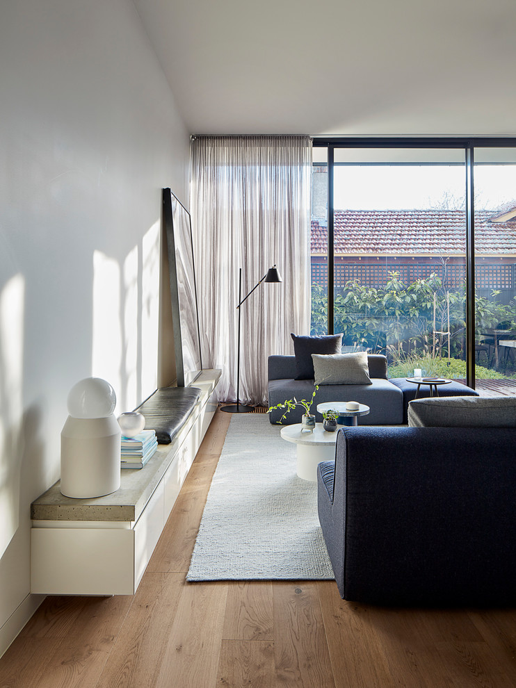Idee per un soggiorno moderno di medie dimensioni e aperto con pareti bianche e parquet chiaro