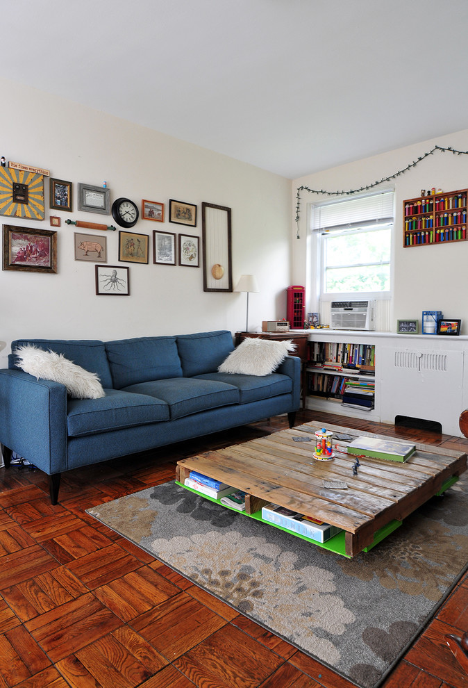 На фото: маленькая гостиная комната в стиле ретро с белыми стенами и синим диваном для на участке и в саду