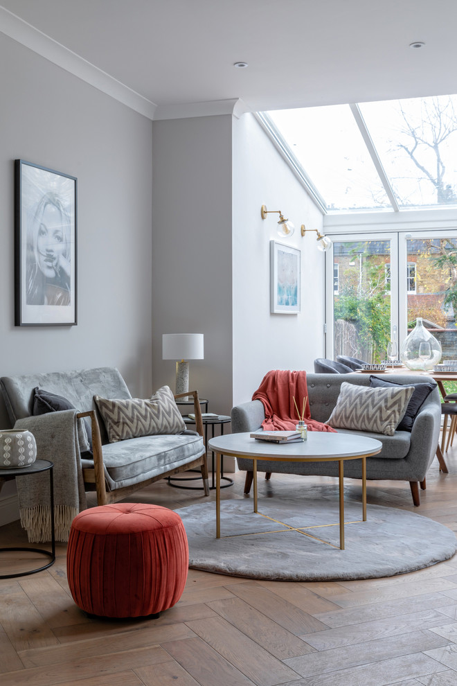 Idee per un soggiorno classico con pareti grigie, pavimento in legno massello medio e pavimento marrone