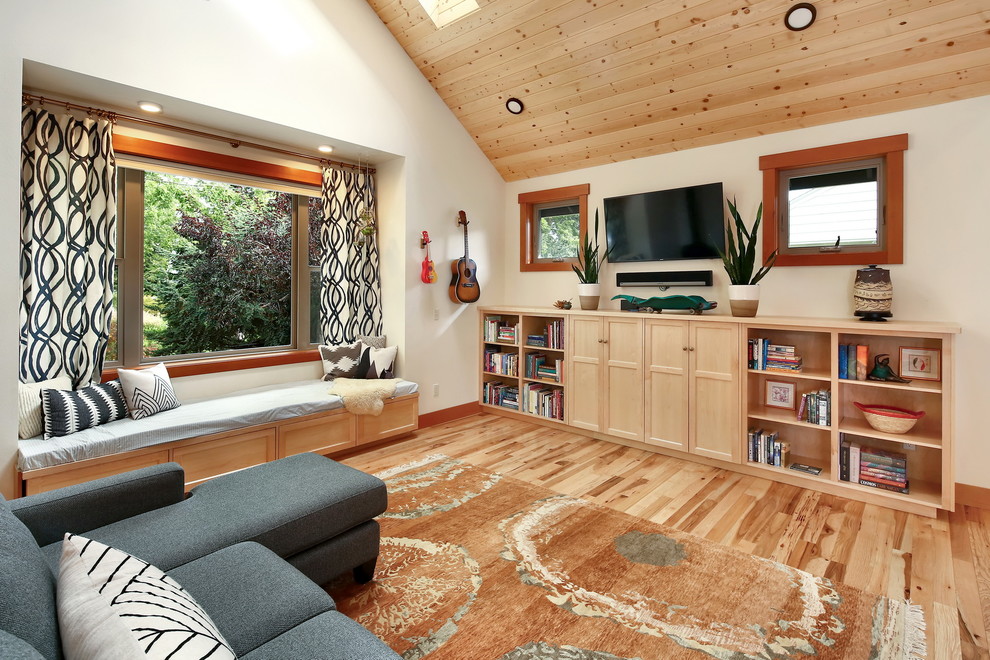 Aménagement d'un salon montagne ouvert avec un mur blanc, un téléviseur fixé au mur, un sol en bois brun et un sol marron.