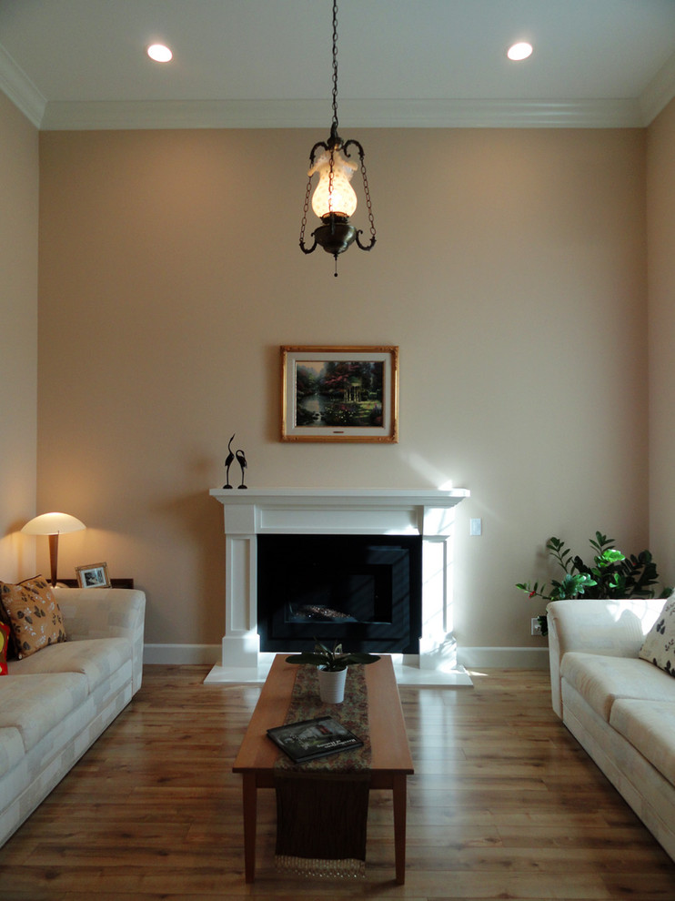 На фото: парадная, изолированная гостиная комната среднего размера в стиле модернизм с коричневыми стенами, полом из ламината, стандартным камином, фасадом камина из дерева и разноцветным полом с