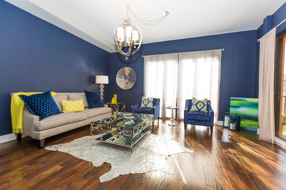 Photo of a large classic open plan living room in Miami with blue walls, dark hardwood flooring, a freestanding tv and feature lighting.