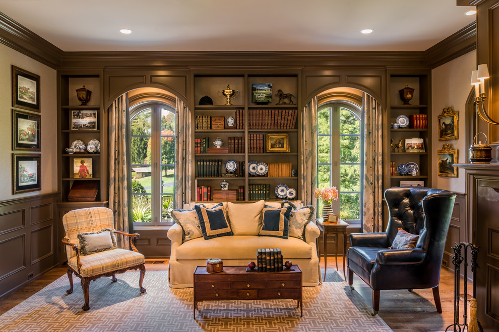 Foto di un grande soggiorno classico chiuso con libreria, pareti beige, pavimento in legno massello medio e nessuna TV