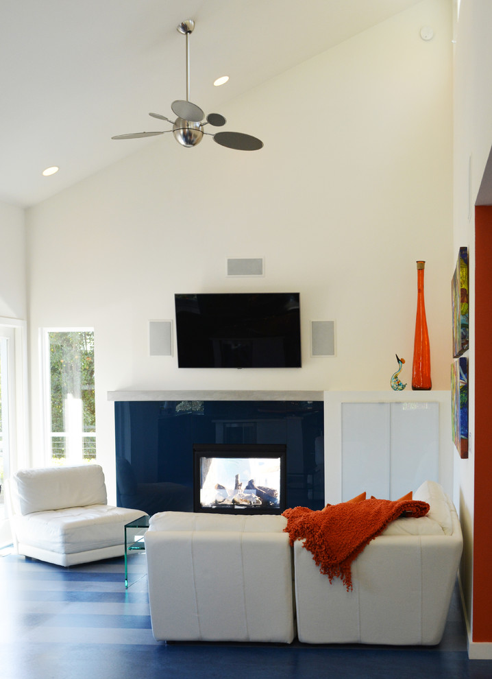На фото: открытая гостиная комната среднего размера в современном стиле с белыми стенами, полом из линолеума, двусторонним камином и телевизором на стене
