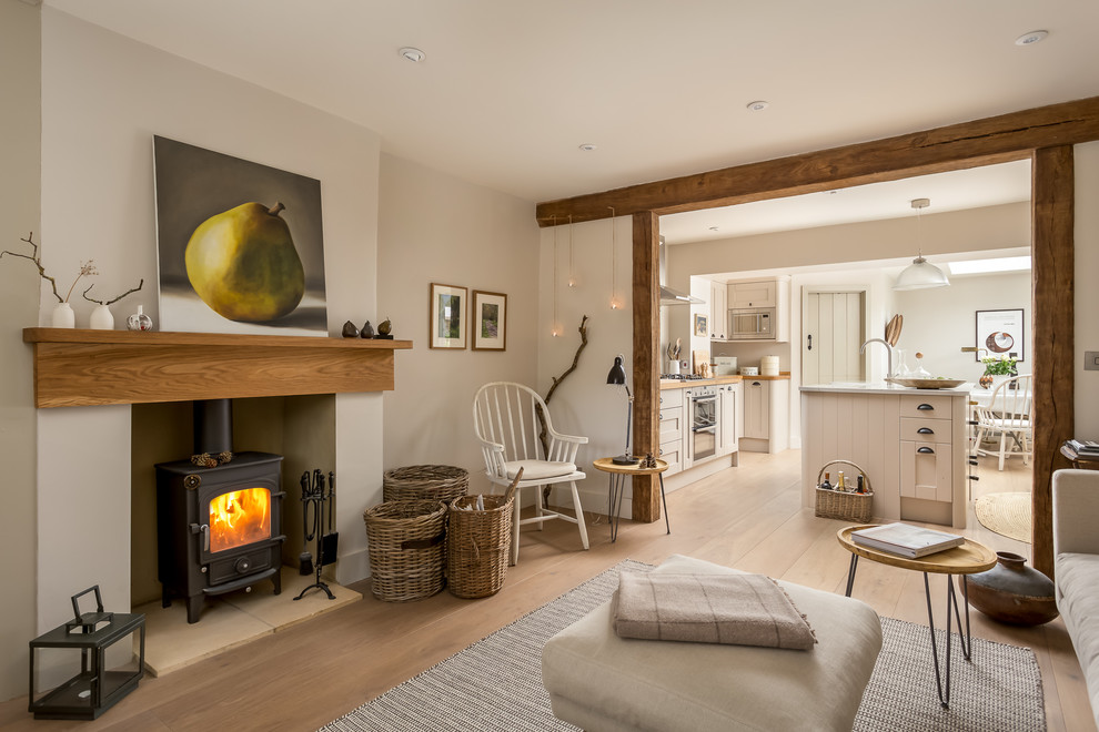 Design ideas for a medium sized rural formal open plan living room in Gloucestershire with beige walls, a wood burning stove and brown floors.
