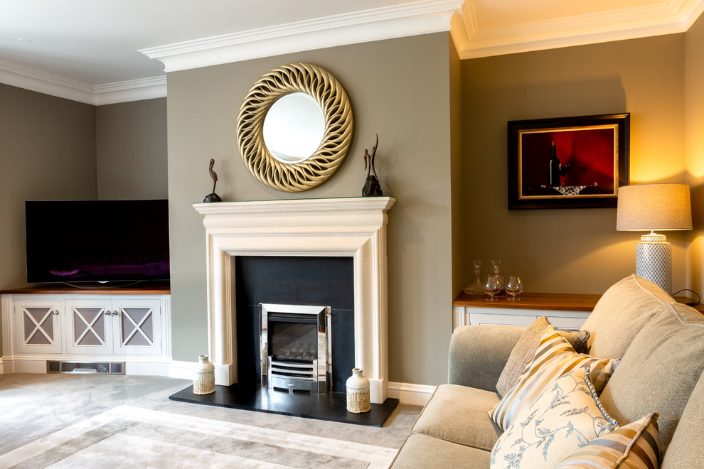 Aménagement d'un grand salon classique avec moquette, une cheminée standard, un manteau de cheminée en pierre, un téléviseur indépendant et un sol gris.