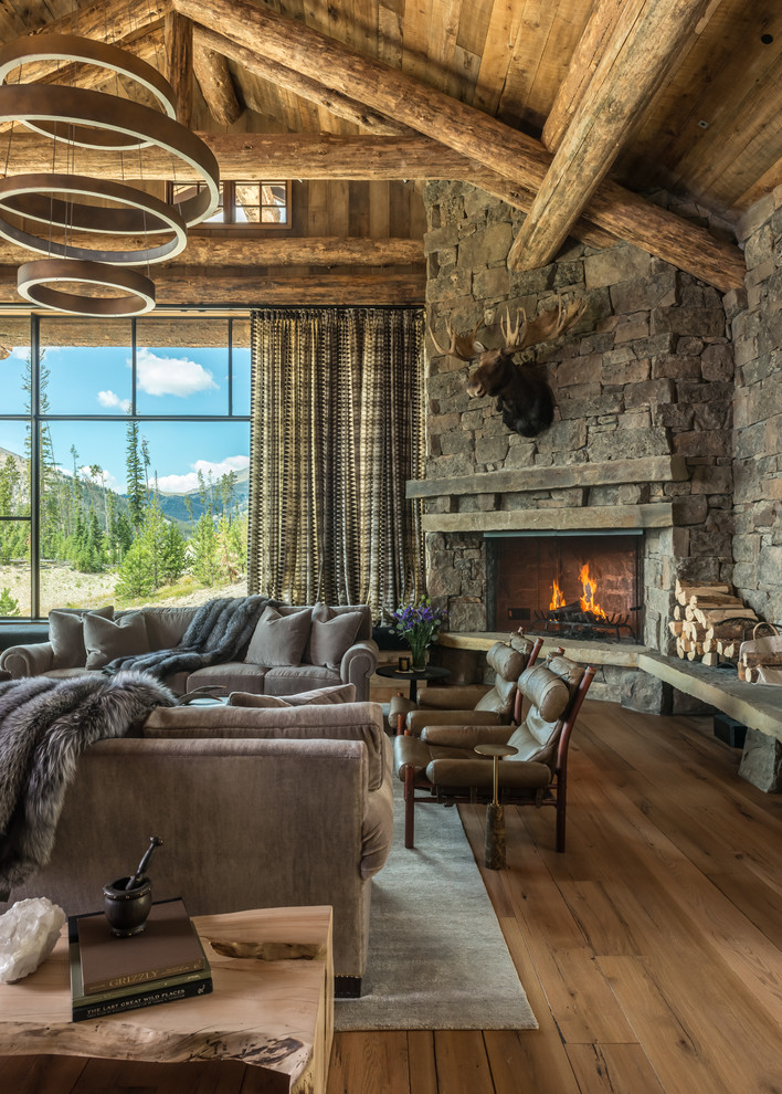 Large rustic formal open plan living room in Other with brown walls, medium hardwood flooring, a corner fireplace, a stone fireplace surround, no tv and brown floors.