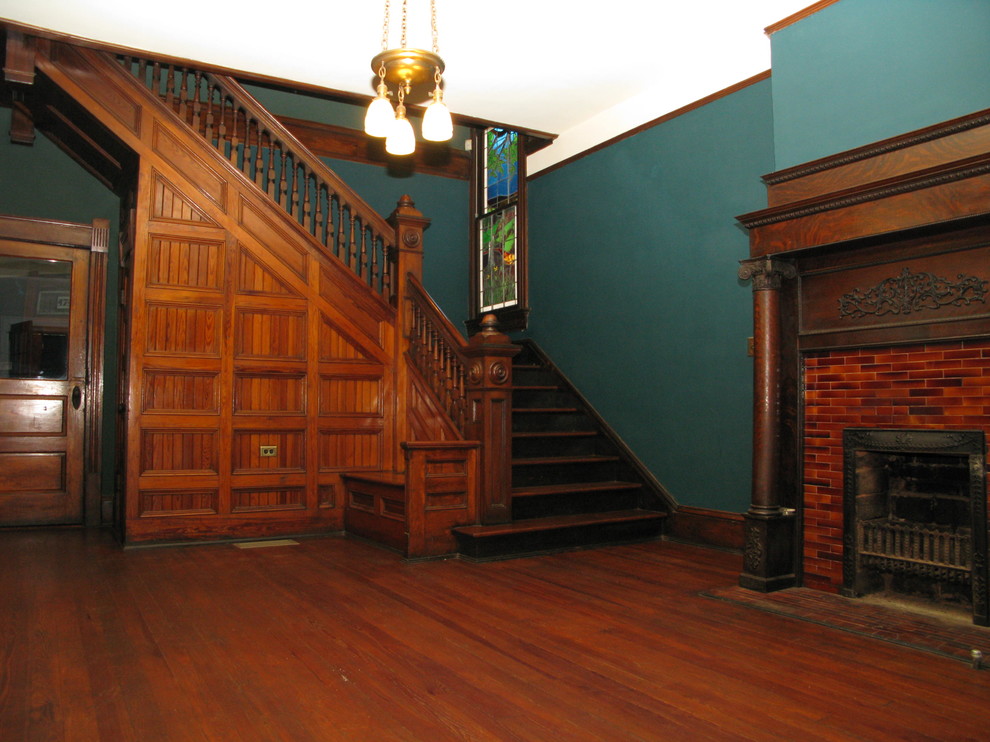 Foto de salón tradicional con paredes verdes, suelo de madera oscura, todas las chimeneas y marco de chimenea de baldosas y/o azulejos