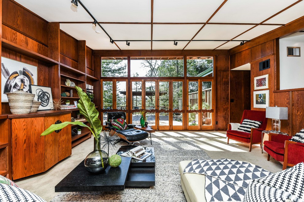This is an example of a large midcentury formal enclosed living room in San Francisco with brown walls, carpet, no fireplace, no tv, grey floors and feature lighting.
