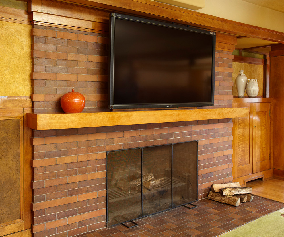 Inspiration for a medium sized midcentury enclosed living room in Chicago with brown walls, light hardwood flooring, a standard fireplace, a brick fireplace surround and a wall mounted tv.